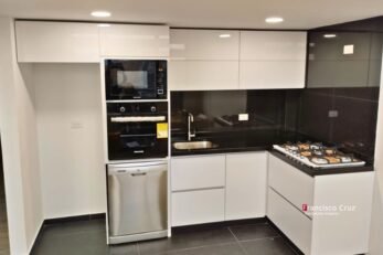 Gabinetes blancos con mesón negro en cocina integral diseñada a medida en Bogotá Barrios Unidos