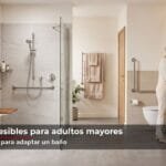 Baño accesible para adulto mayor con ducha a ras de suelo, asiento plegable en madera, barras de apoyo y mueble de lavamanos suspendido | Francisco Cruz Interiores