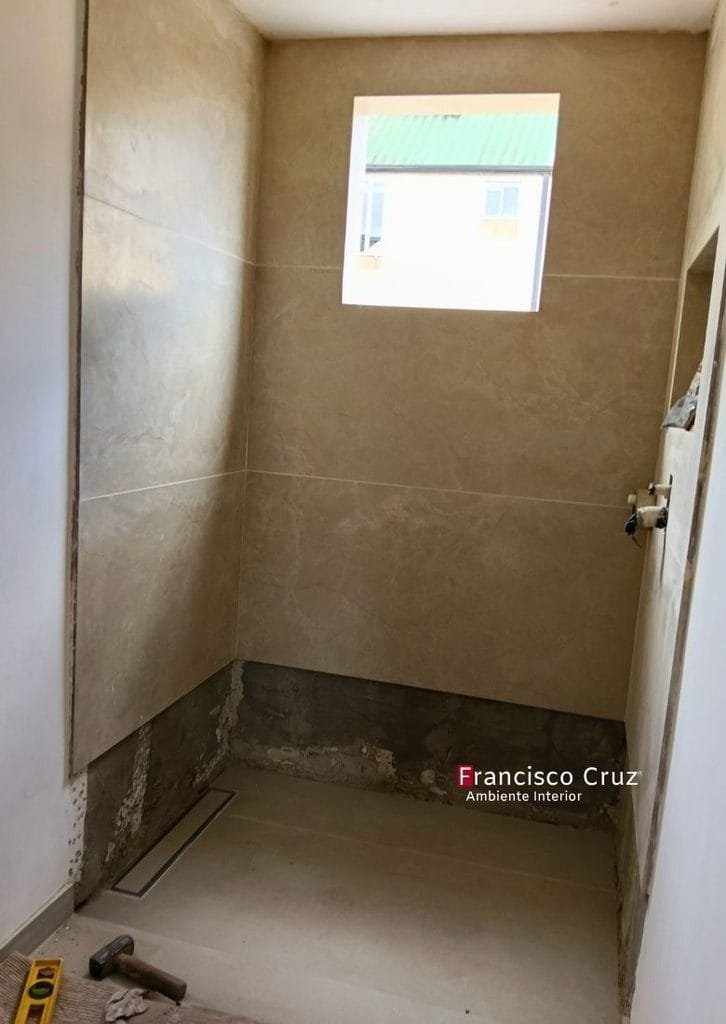 Muros de ducha con enchape rectangular y piso en mortero nivelado para la instalación de cerámica.