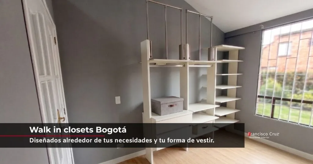 Walk in closet en Bogotá bajo techo inclinado, con barras colgantes, entrepaños y cajones en tono blanco