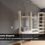 Walk in closet en Bogotá bajo techo inclinado, con barras colgantes, entrepaños y cajones en tono blanco