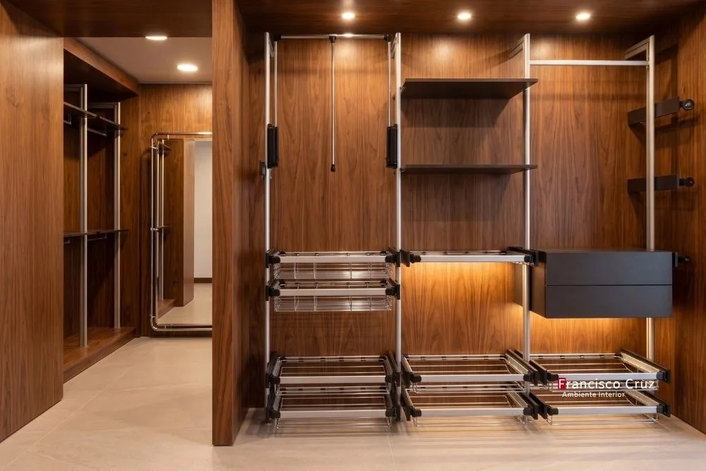 Walk in closet moderno en madera nogal con zapateras extraíbles metálicas y cajones con iluminación integrada